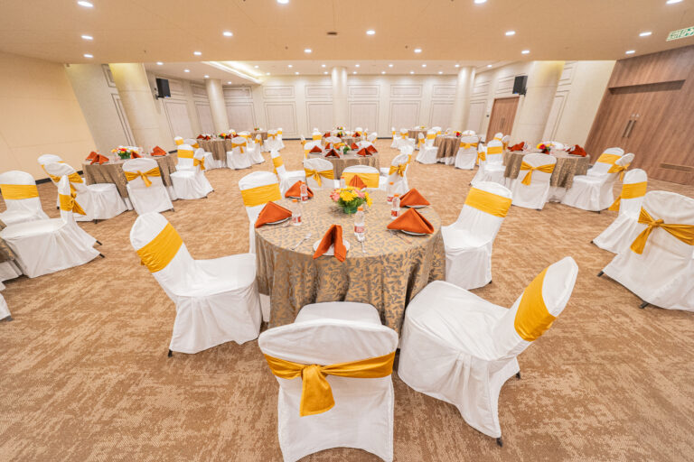 Regalia banquet hall set with round tables at Regent Club, Whitefield